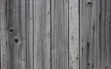 Old gray background from vertical wooden boards. Stock photography. 