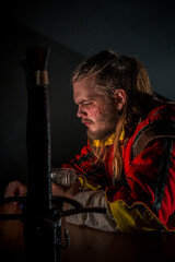 Fototapeta premium Witcher in a bar with smoke drinking beer