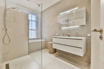 Contemporary interior design of light tiled bathroom with shower unit and white furniture in modern apartment