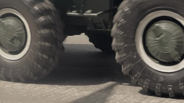 Close-up of rubber tires of a moving armored personnel carrier at a military parade.