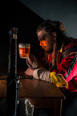 Witcher in a bar with smoke drinking beer