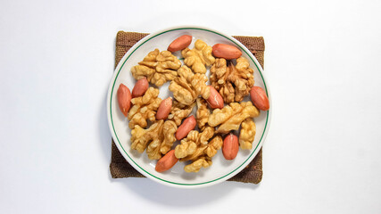Peeled walnuts and peanuts on a saucer. Dietary nutrition.