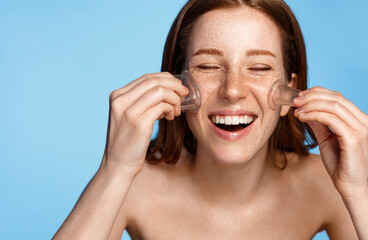 Skin care and rejuvenation. Smiling woman with fresh glowing skin, laughing and massaging skin with...