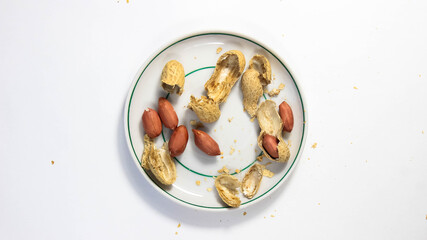 Peanuts in a shell that flakes on a saucer.
