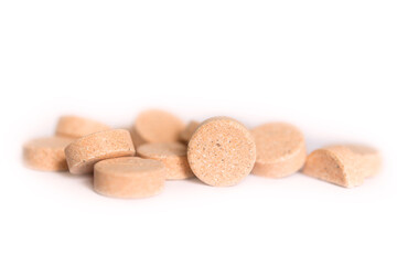 Natural plant pills on a white background. Round herbal tablets close-up. Healthcare and medicine. Homeopathy and Alternative Medicine