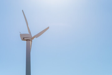 One wind power turbine and blue sky.wind power concept with copy space. Technology in nature environment.