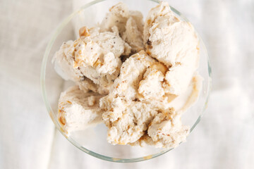 Top view of vanilla ice cream with chocolate chip cookies, chocolate chips and caramel sauce.