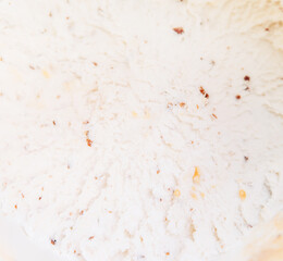 Top view of vanilla ice cream with chocolate chip cookies, chocolate chips and caramel sauce.