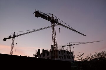 The construction site of a new housing estate - construction and cranes in the morning sun
