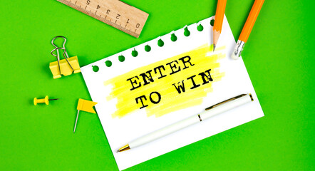 Text ENTER TO WIN sign showing on gren background with office tools