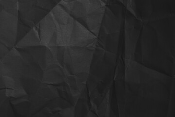 Black background of crumpled paper in the dark