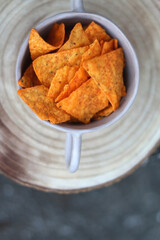Bowl of spicy tortilla chips on a table. Flat lay.