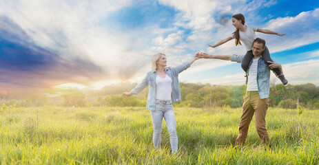 Fototapeta premium Young happy family in a field