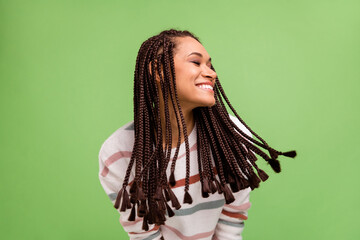 Photo of cheerful happy afro american young woman good mood fly hair isolated on green color...