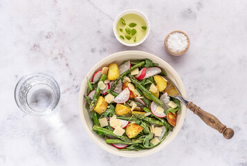 Summer salad with potatoes, green asparagus, arugula, and radishes. Seasonal diet food.