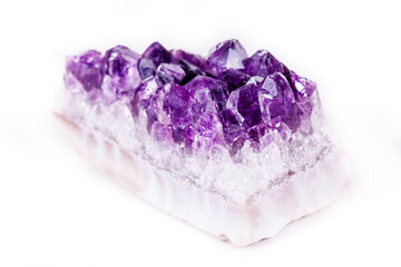 Macro mineral stone purple amethyst in crystals on a white background