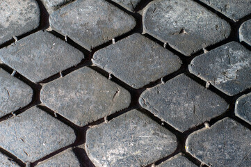 background texture of the tread of an old car tire in the form of diamonds