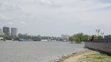 Fototapeta premium View of the city from the left bank. On the Don River, a ships sails. Citizens watch the city