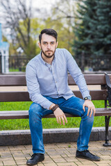 Portrait of a man who sits on a bench and thinks