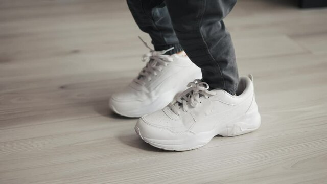 Little baby boy trying to wear daddy's big shoes