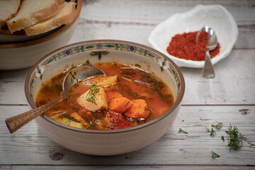 Vegan carrot and potato soup in  ceramic bowl on wooden table, copy space