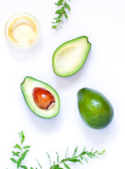 Halves of fresh avocado fruits close up on the white table. Top view