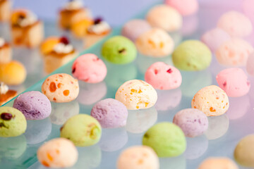 The colorful shortbread and delicate berry cream grape cakes are placed on the snack table of a Western-style outdoor wedding, which looks quite delicious