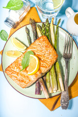 Vegan healthy food, keto diet recipe, Baked grilled salmon fish steak with green, white, purple asparagus , light blue sun lighted background top view copy space
