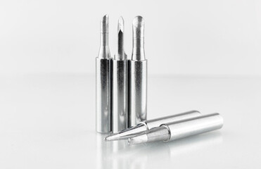 Set of soldering tips for soldering iron on glass table background, close-up photo