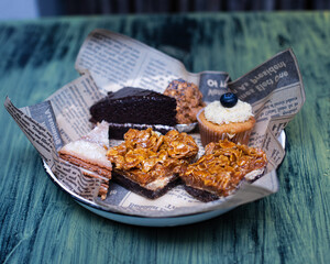 A plate with cupcakes, pecan pie and chocolate cake slices