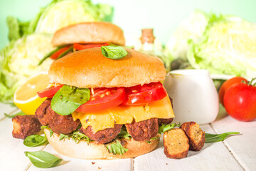 Falafel and fresh vegetables burger. Vegan cheeseburger with roasted falafel, israeli traditional food, with yoghurt sauce copy space