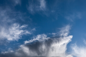 Cloudscape photo of blue sky and white and grey clouds