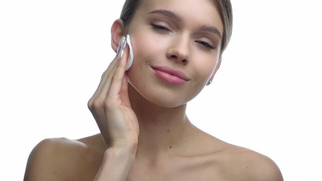 happy woman removing makeup with cotton pad isolated on white
