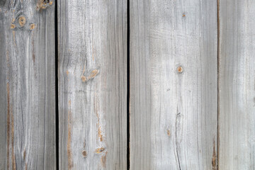 Grey color wall made of uncutted weathered wood boards.