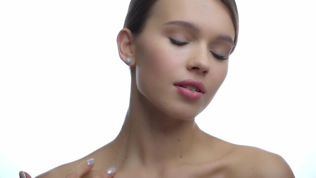 young woman touching clavicle isolated on white