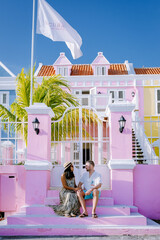 Curacao, colorful bouldings around Willemstad Punda and Otrobanda Pietermaai district, multicolored homes in Pietermaai Curacao Caribean Island , couple men and woman on vacation Curacao - obrazy, fototapety, plakaty