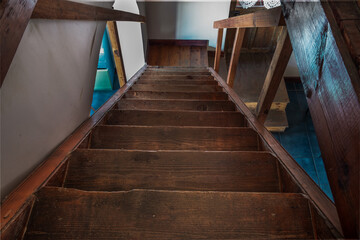 Photo of descending old wooden staircase