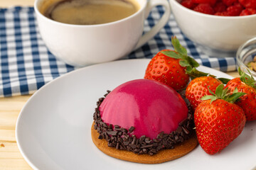Pink glazed dessert with fresh strawberries on plate