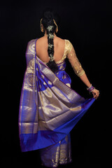 Obraz na płótnie Canvas Indian woman in bridal look in blue saree. Back view.