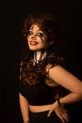 Woman with brown hair and painted face. Joker makeup. Looking at camera. Closeup of face