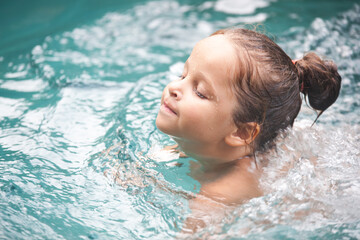 Pretty little girl in swimming pool