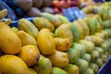 Colorful fruit stand with mangoes, small bananas, and more