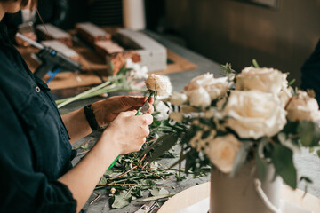 Woman florist creates stylish bouquet, small business concept, unrecognizable person