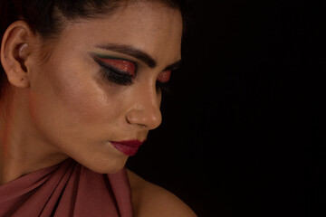 Fototapeta premium Portrait of young girl looking down Hands on face. Black background. Closeup of face.