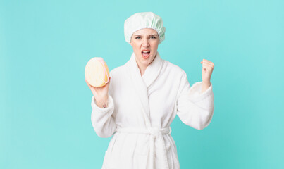 blond pretty woman shouting aggressively with an angry expression and wearing bathrobe
