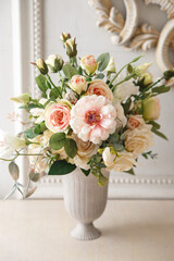 Delicate decorative bouquet of roses in a vase on the table.