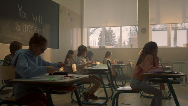 Kids sitting at school desks in classroom. Students preparing for lesson