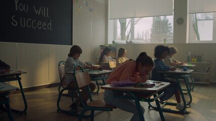 Obraz na płótnie Canvas Schoolchildren studying in school class. Students doing class work in auditorium