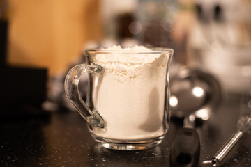 A glass filled with flour. Preparation of products for cooking.