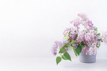 Floral layout with branches of blooming lilacs in a gray pot. Spring, summer template for banner, postcard, social media. Copy space.
